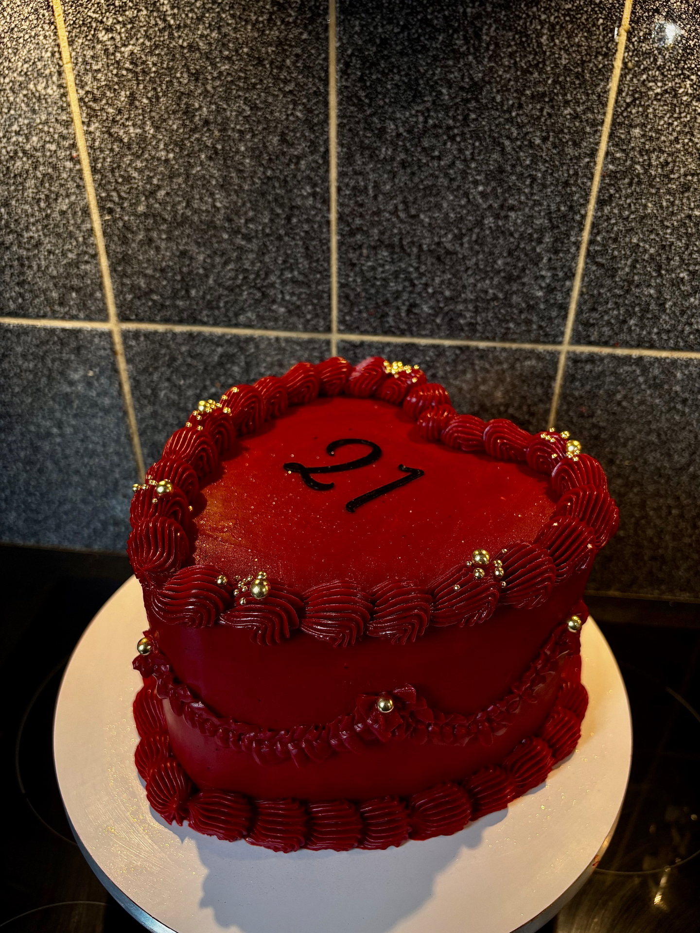 Rode taart met gouden details en '21' topper