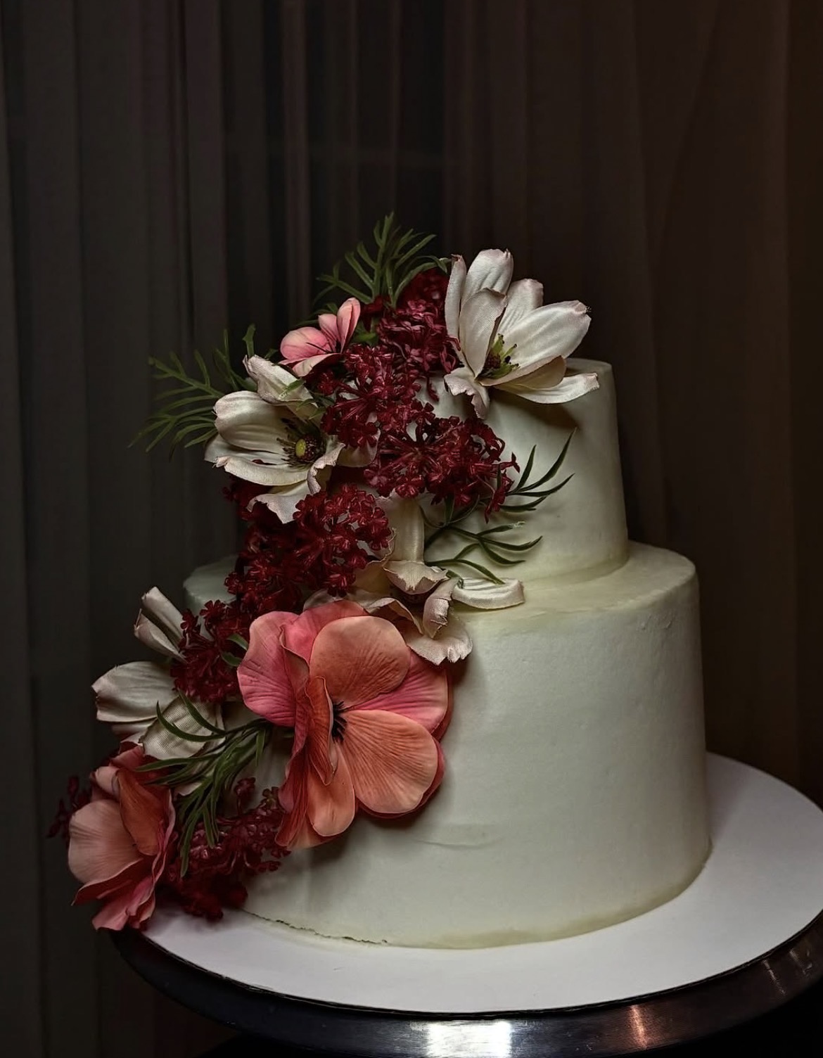 Witte taart met roze en rode bloemen